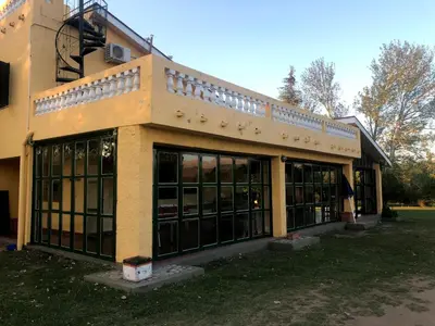 a building with a lot of windows in a yard at Casa grande La Querencia in Villa Cura Brochero