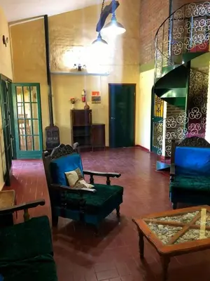 a living room with chairs and a couch and a table at Casa grande La Querencia in Villa Cura Brochero