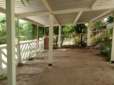 a covered porch with white columns and a fence at Rosa de los Vientos in Nono