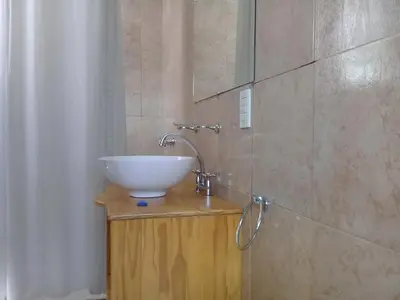 a bathroom with a sink and a shower curtain at Rosa de los Vientos in Nono