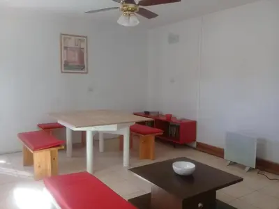 a dining room with a table and chairs and a ceiling fan at Rosa de los Vientos in Nono