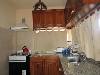 a kitchen with wooden cabinets and a stove and a sink at Terrazas De Potrero in Potrero de Garay