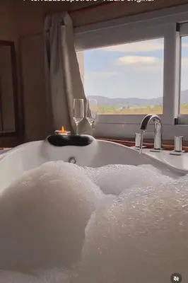 a bath tub with a candle and a window at Terrazas De Potrero in Potrero de Garay