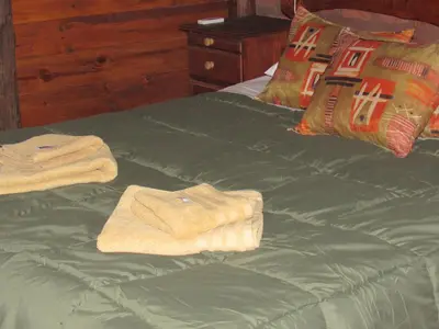 a bed with green sheets and towels on it at Terrazas De Potrero in Potrero de Garay