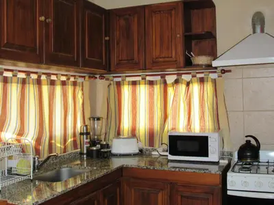 a kitchen with wooden cabinets and a counter top at Terrazas De Potrero in Potrero de Garay