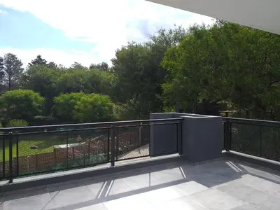 a balcony with a black fence and trees at COMPLEJO AYRES DE MAYU SUMAJ in Villa Carlos Paz