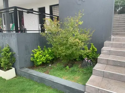 a building with some bushes next to a staircase at COMPLEJO AYRES DE MAYU SUMAJ in Villa Carlos Paz