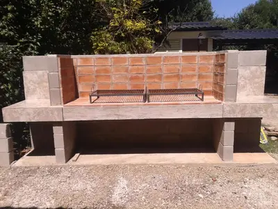 a stone bench sitting in front of a brick wall at Aires de las Sierras 2 in Villa Carlos Paz