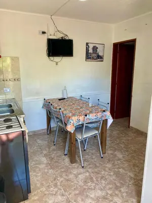 a dining room table with chairs and a television on the wall at Aires de las Sierras 2 in Villa Carlos Paz
