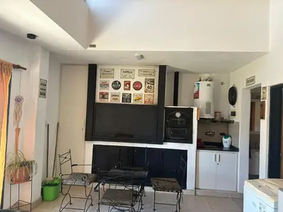 a kitchen with chairs and a counter with a tv at HERMOSA CASA 2 DORMITORIOS EN POTRERO DE GARAY in Potrero de Garay