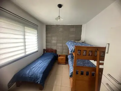 a bedroom with two bunk beds and a window at HERMOSA CASA 2 DORMITORIOS EN POTRERO DE GARAY in Potrero de Garay