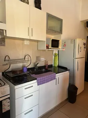 a kitchen with white cabinets and a sink and a refrigerator at HERMOSA CASA 2 DORMITORIOS EN POTRERO DE GARAY in Potrero de Garay