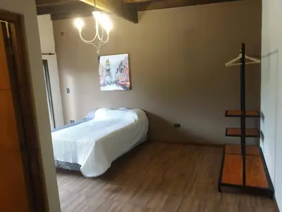 a bedroom with a bed and a lamp in it at CABAÑAS EXCLUSIVAS LAS ROSAS - CORDOBA in Villa de Las Rosas
