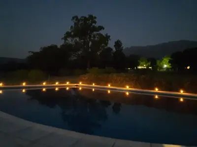 a night view of a swimming pool with lights at CABAÑAS EXCLUSIVAS LAS ROSAS - CORDOBA in Villa de Las Rosas