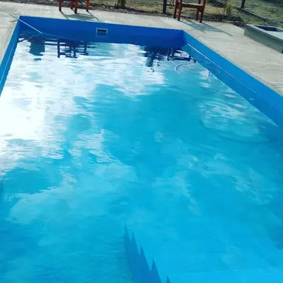 a large pool of blue water in a yard at Susurro de Montaña (TIERRA SANTA) in San Lorenzo