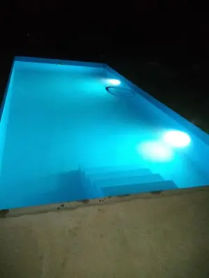 a pool with blue lights on top of it at Susurro de Montaña (TIERRA SANTA) in San Lorenzo