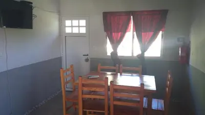 a dining room table with two chairs and a window at Susurro de Montaña (TIERRA SANTA) in San Lorenzo