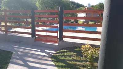 a wooden fence next to a swimming pool at Tierra Santa in Villa Cura Brochero