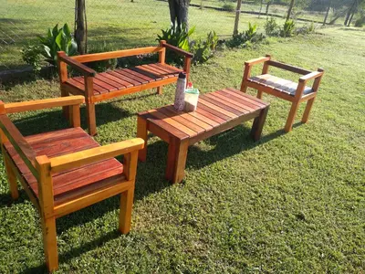 three wooden benches sitting on the grass in a field at Tierra Santa in Villa Cura Brochero