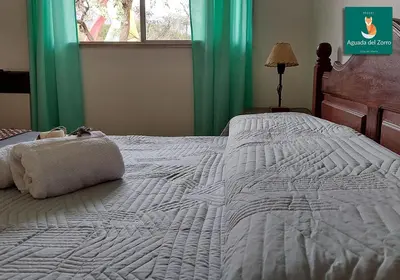 a large white bed with a pillow on it at Nuevo Hotel Aguada del Zorro in Merlo