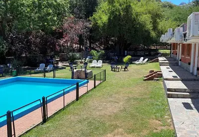 a swimming pool in a yard next to a house at Nuevo Hotel Aguada del Zorro in Merlo