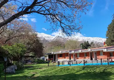 a red brick building with mountains in the background at Nuevo Hotel Aguada del Zorro in Merlo