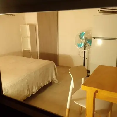 a room with a bed and a table and a refrigerator at Casa Abierta in Nono