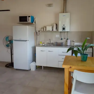 a kitchen with a white refrigerator and a table at Casa Abierta in Nono