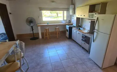 a kitchen with a white refrigerator and a table at Casa Abierta in Nono