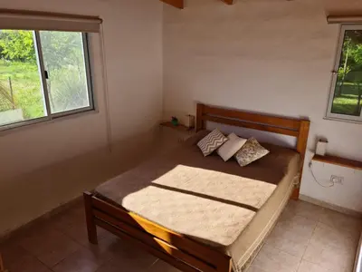 a bedroom with a bed in a room with two windows at Casa Abierta in Nono