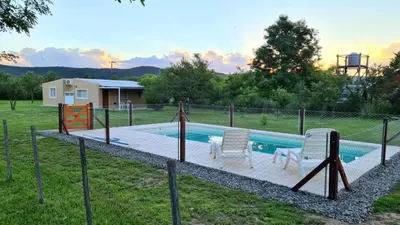 a swimming pool with two chairs and a fence at Casa Abierta in Nono