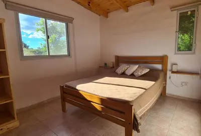 a bedroom with a bed and two windows at Casa Abierta in Nono
