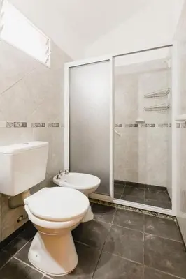 a bathroom with a toilet and a shower and a sink at Gran Turín Hotel Boutique parque,arte y tecnología in Villa Carlos Paz