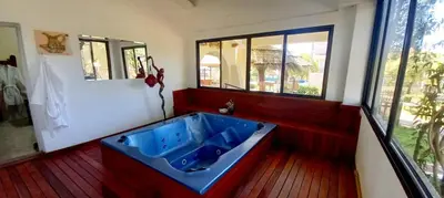 a bathroom with a blue tub in a room with windows at Gran Turín Hotel Boutique parque,arte y tecnología in Villa Carlos Paz