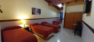 a hotel room with two beds and a hallway at Gran Turín Hotel Boutique parque,arte y tecnología in Villa Carlos Paz