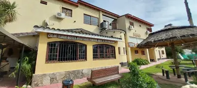 a building with a bench in front of it at Gran Turín Hotel Boutique parque,arte y tecnología in Villa Carlos Paz