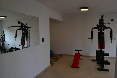 a gym with two rows of equipment in a room at Dto con pileta en Carlos Paz 33! in Villa Carlos Paz