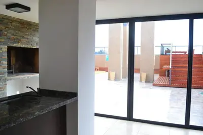a kitchen with sliding glass doors and a fireplace at Dto con pileta en Carlos Paz 33! in Villa Carlos Paz