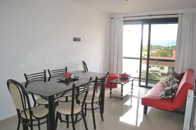 a dining room with a table and chairs and a couch at Dto con pileta en Carlos Paz 33! in Villa Carlos Paz
