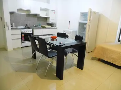 a black table and chairs in a small kitchen at Ayres de Las Sierras in Villa Carlos Paz