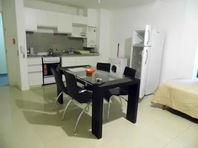 a kitchen with a black table and chairs in a room at Ayres de Las Sierras in Villa Carlos Paz