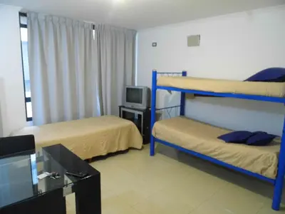 a room with two bunk beds and a television at Ayres de Las Sierras in Villa Carlos Paz