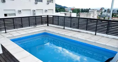 a swimming pool on the roof of a building at Serena in Villa Carlos Paz