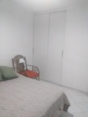 a bedroom with a bed and a chair and a closet at Serena in Villa Carlos Paz