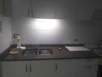 a kitchen counter with a sink and a light at Serena in Villa Carlos Paz
