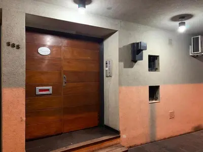 a wooden door in a hallway with a clock on it at Serena in Villa Carlos Paz