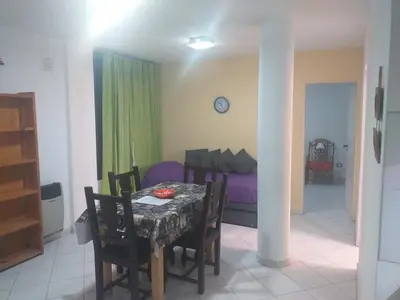a dining room with a table and a bed at Serena in Villa Carlos Paz
