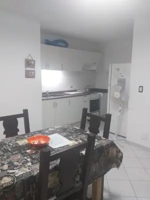 a kitchen with a dining room table and a table and chairs at Serena in Villa Carlos Paz