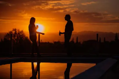 a man and a woman standing in front of the sunset at ÑU Posta Urbana Hotel Boutique in Cordoba