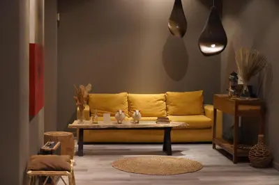a living room with a yellow couch and a table at ÑU Posta Urbana Hotel Boutique in Cordoba